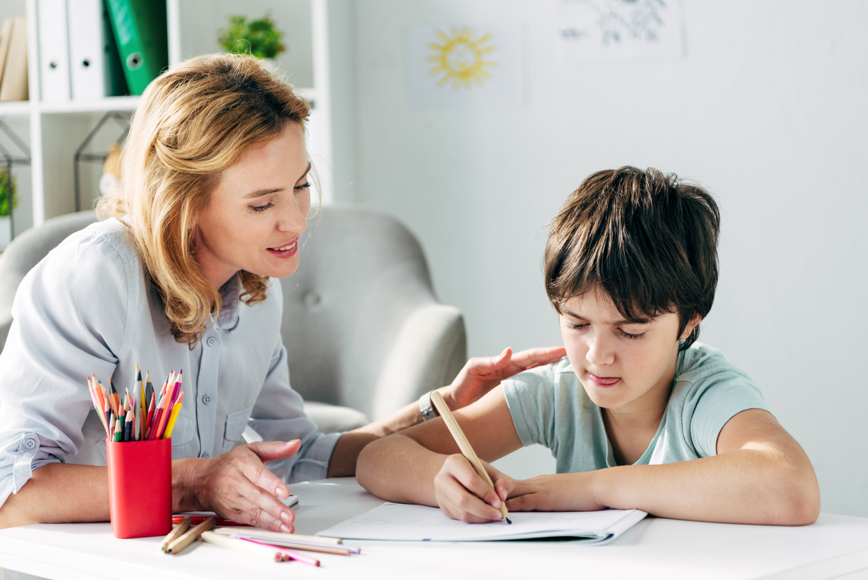 A tutor working one-on-one with a student using reading and writing materials, illustrating personalized tutoring funded through Florida’s PEP scholarship program.