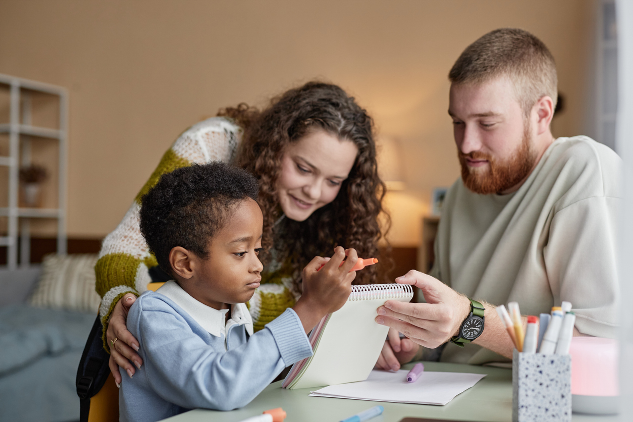 A parent and student reviewing learning materials with a tutor, representing educational support funded through Florida’s Step Up for Students scholarship program.