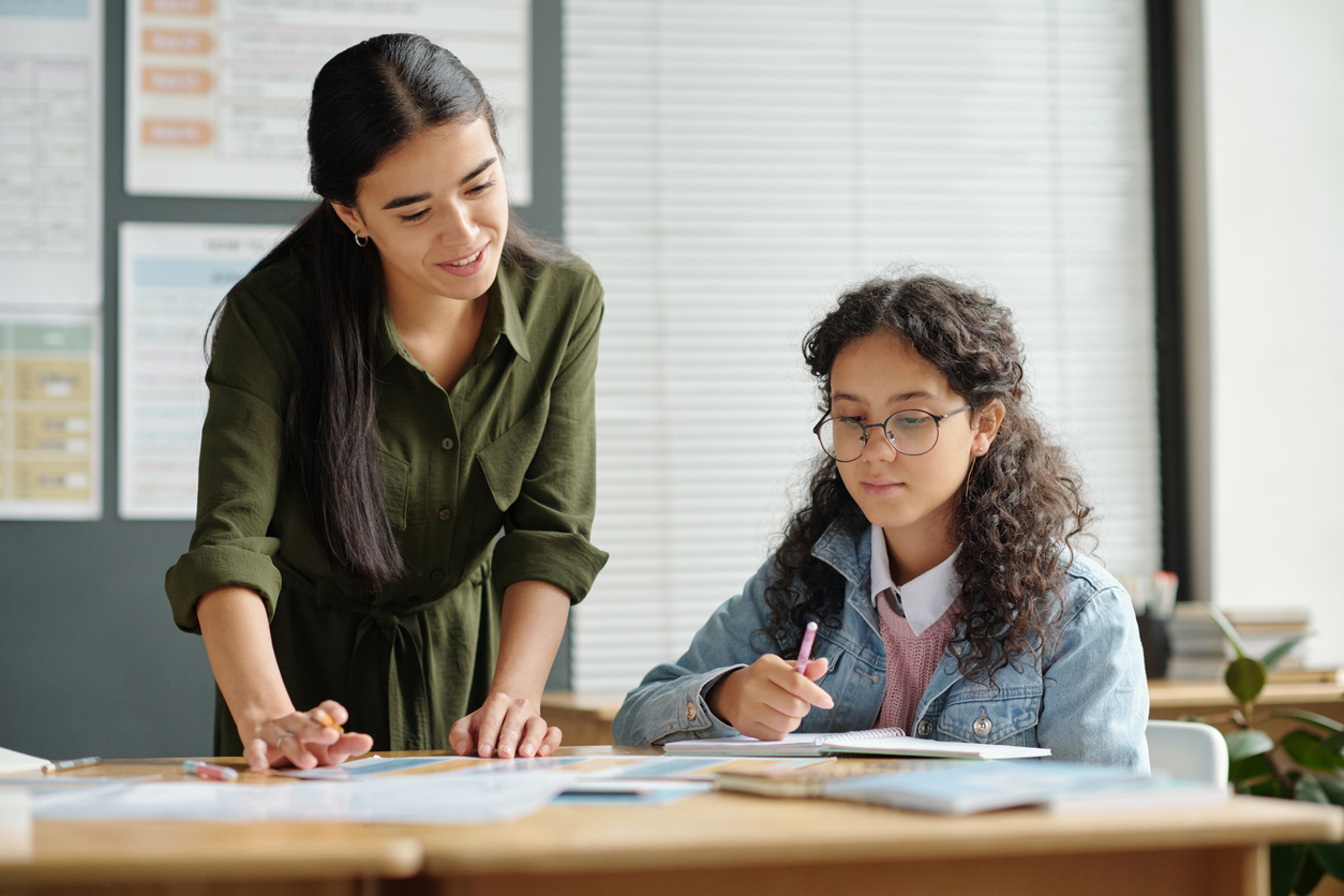 A tutor working one-on-one with a student at a desk reviewing schoolwork, illustrating personalized tutoring support in Boca Raton.
